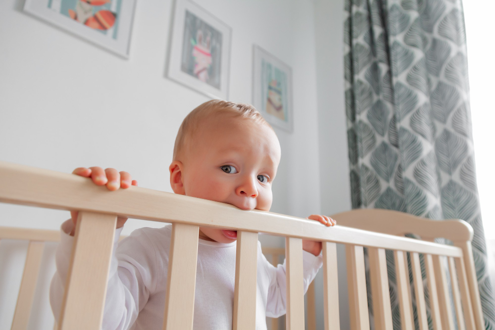 rubio lindo bebe mordiendo cabecera cama madera