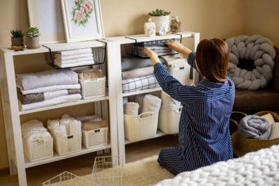 mujer domestica pijama cuidadosamente poniendo ropa cama doblada armario almacenamiento vertical marie kondo